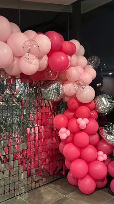 pink and white balloons are on display at a party