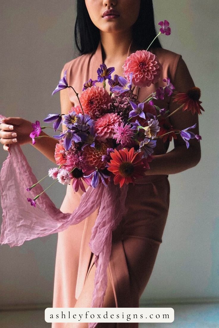 a woman holding a bouquet of flowers in her hands