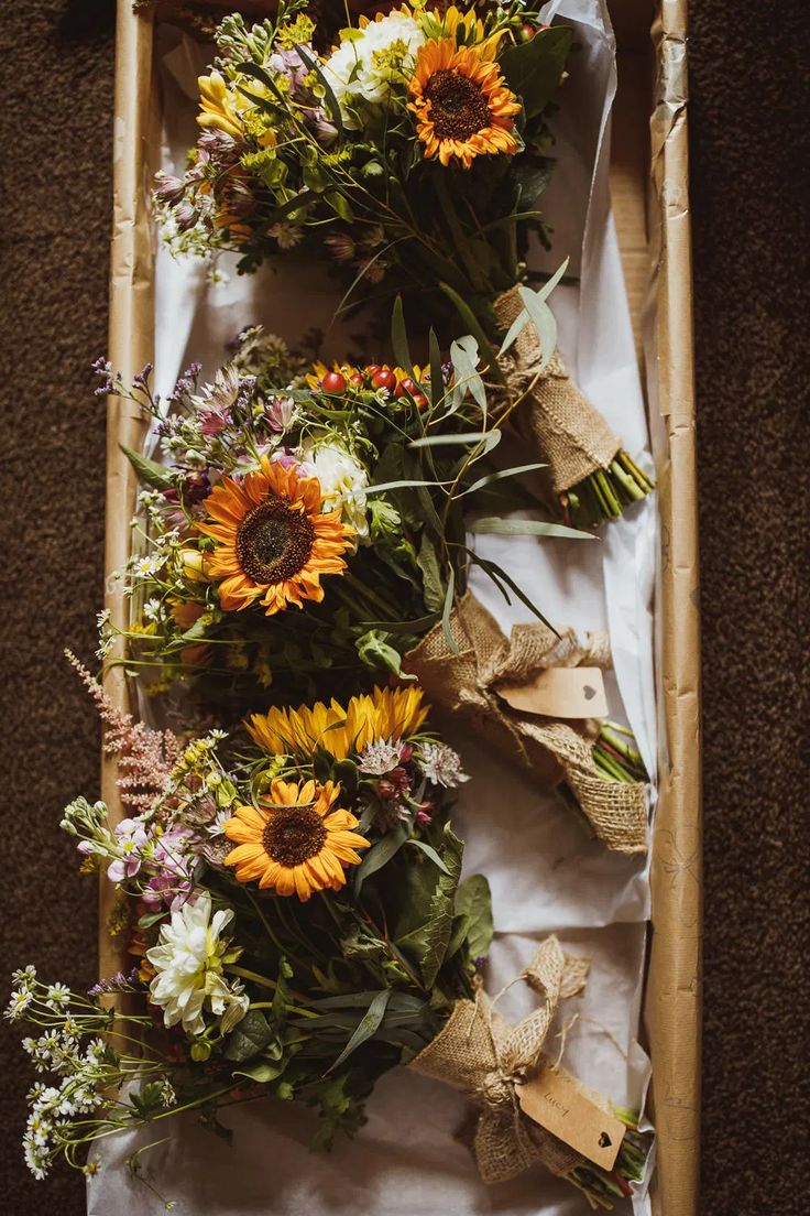 sunflowers and other flowers are laid out on the floor next to each other