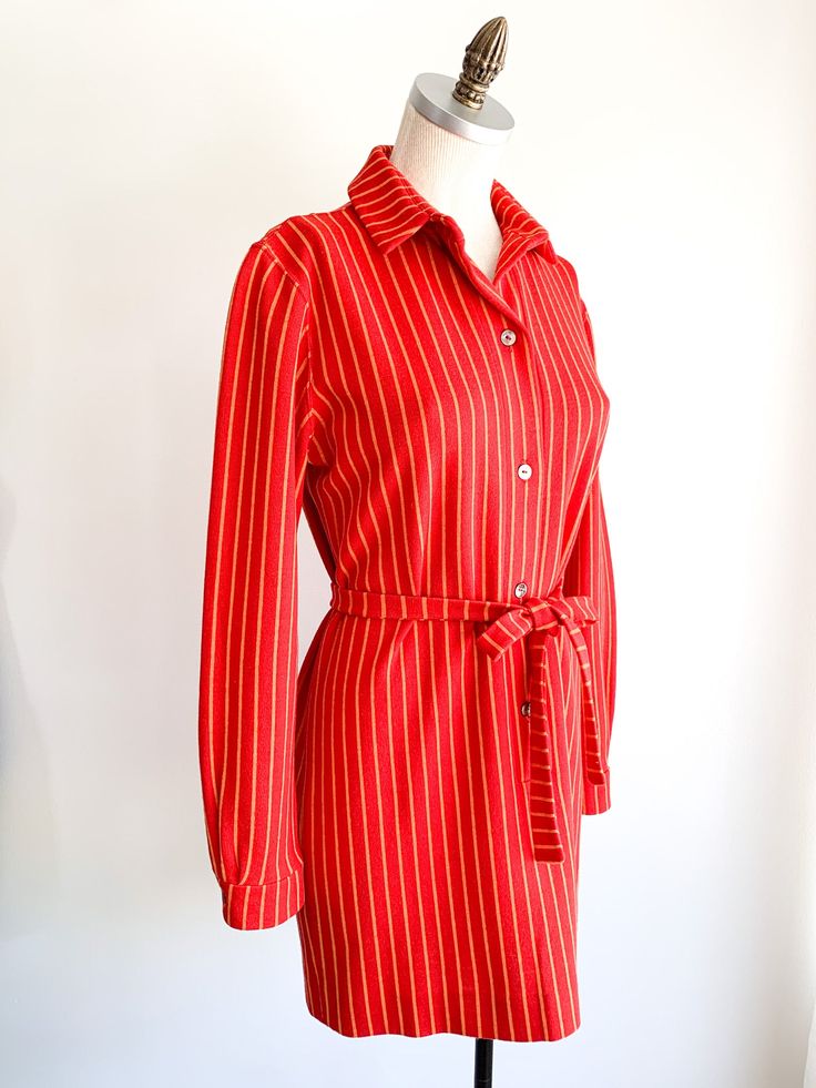 Vibrant poppy with yellow stripes throughout mini shirt dress with button front, collar and tie. Fabric: WoolLabel: Rudi GernreichFit: S/MEra: 1960's Measurements: Bust 38" Shoulder 16.5" Sleeve 23.5" Length 32" Waist 36" Hips 37" Belt 1" x 59" Condition: Very good. One pin hole on back of collar and one tiny snag on left shoulder (see photos). Dress has been shortened. Striped Collar Shirt Dress, Classic Striped Shirt Dress For Work, Fall Striped Collared Shirt Dress, Fitted Striped Shirt Dress For Fall, Striped Long Sleeve Shirt Dress For Formal Occasions, Vintage Long Sleeve Shirt Dress For Work, Daywear Shirt Dress With Striped Collar, Striped Shirt Dress With Buttons For Work, Fitted Striped Shirt Dress With Buttons