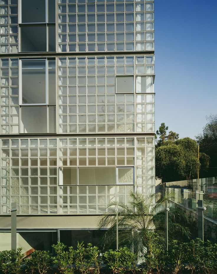 a tall building with lots of windows on it's side and trees in front