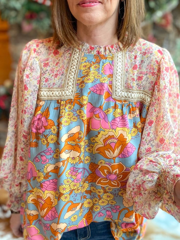 Look blooming fabulous in this Grace Multi-Floral Blouse! From the frill mock neck to the sheer bubble sleeves, this playful top will have you living your best floral fantasy. Plus, the smocked cuffs provide a flattering and comfortable fit. Get ready to brighten up the room! Relaxed fit. I am in the small. You can size down. Sizes: Small-Large 100% Rayon Follow tag instructions for washing. Feminine Fall Smocked Top With Floral Print, Feminine Floral Smocked Top For Fall, Floral Print Puff Sleeve Peasant Top For Brunch, Feminine Floral Print Peasant Top With Puff Sleeves, Multicolor Floral Print Top With Balloon Sleeves, Chic Smocked Lantern Sleeve Top For Spring, Chic Smocked Top With Lantern Sleeves For Spring, Balloon Sleeve Blouse With Smocked Cuffs For Brunch, Feminine Floral Print Blouse With Balloon Sleeves