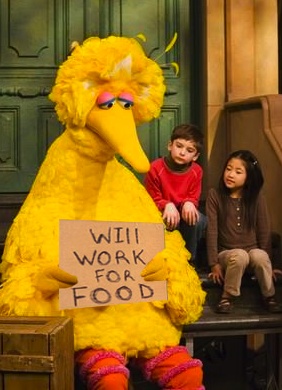 a young boy sitting next to a big bird holding a sign that says will work for food