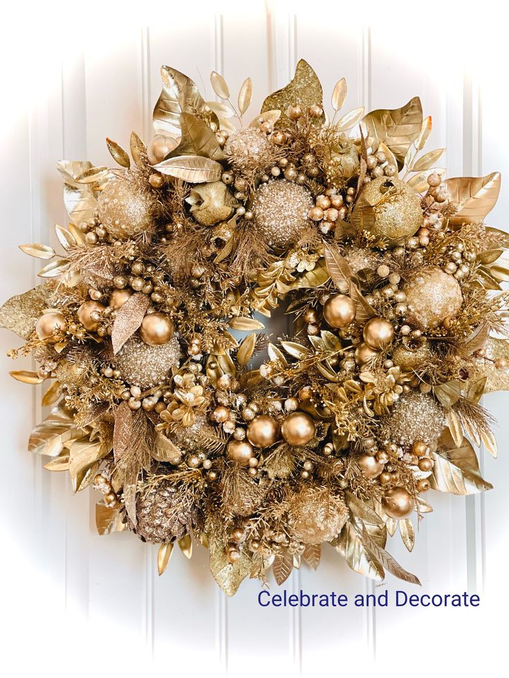 a christmas wreath with gold ornaments and berries on it, hanging on a white door