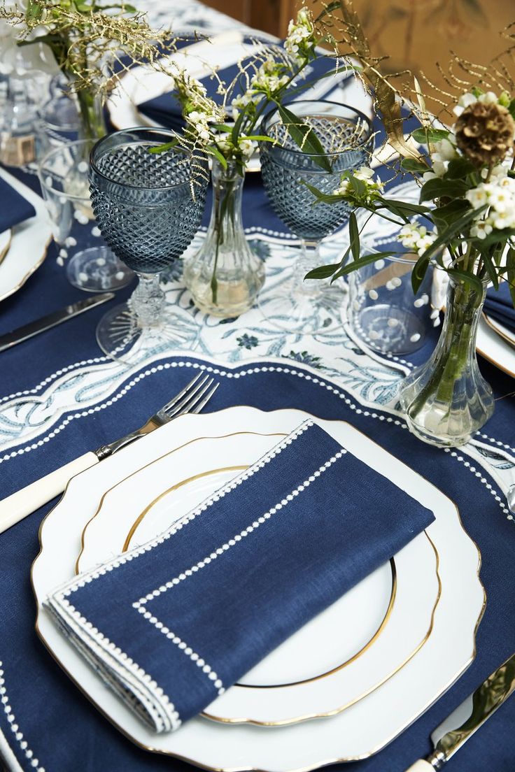 the table is set with blue and white place settings