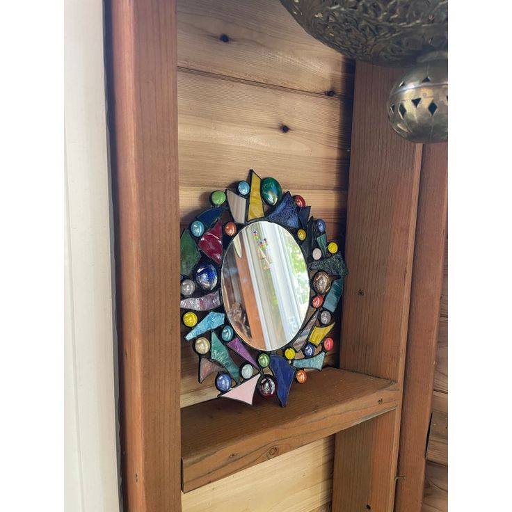 a mirror sitting on top of a wooden shelf