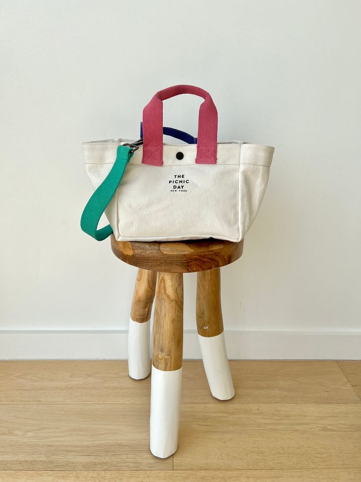 a white bag sitting on top of a wooden stool