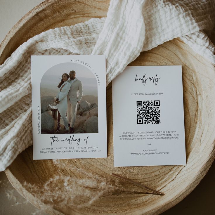 the wedding stationery is laid out on a wooden plate