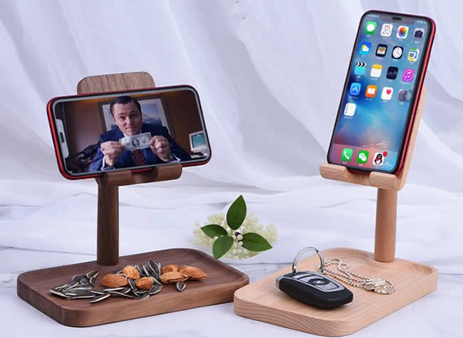 two cell phones on wooden stands with one holding a camera and the other displaying an image