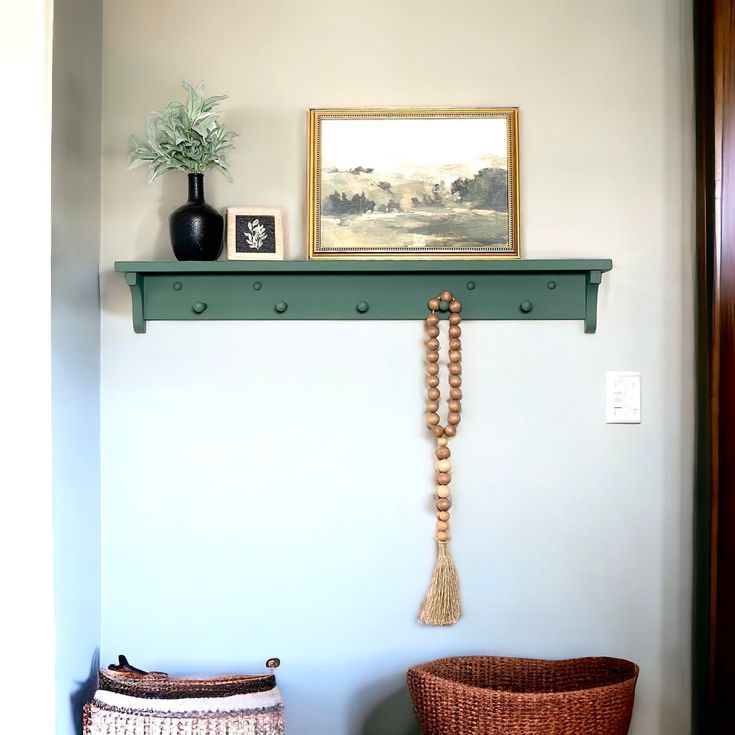 a shelf with beads and a painting on it next to a wicker basket in the corner