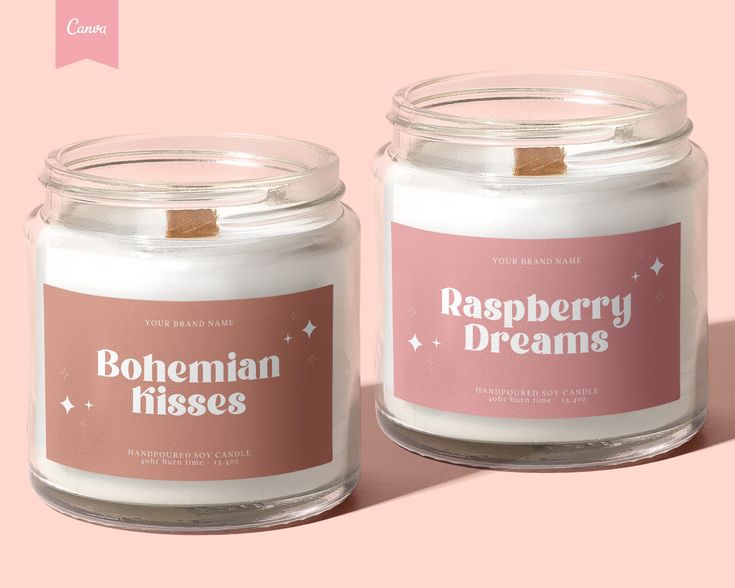 two candles with labels on them sitting side by side in front of a pink background