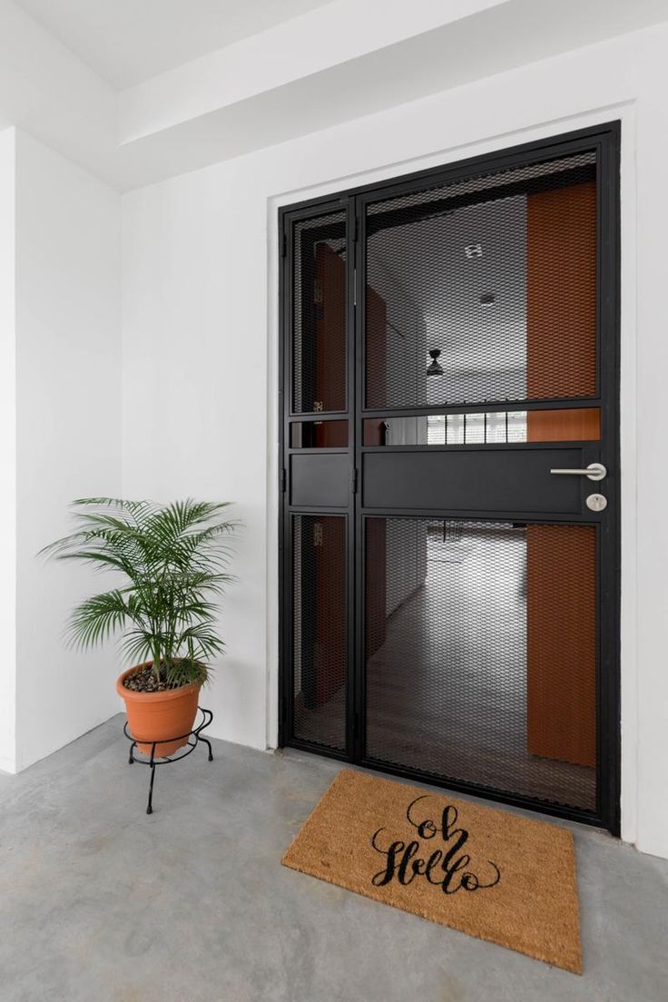 a door mat with the word hello written on it and a potted plant in front