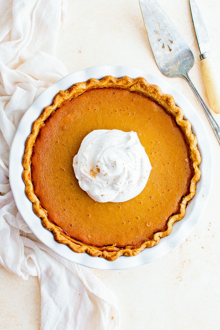 a pumpkin pie with whipped cream on top and the words butternut squash pie above it