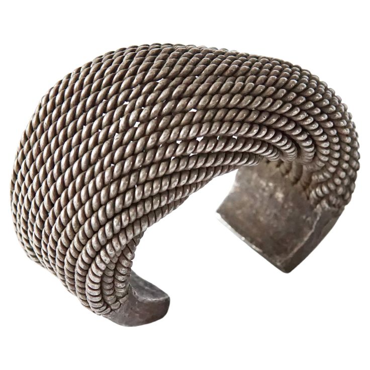 An exceptionally large Akha Tribe woven silver bracelet with spiral design. This Tribal bracelet encompasses tradition Hill tribe silversmithing techniques with each silver strand crafted and woven by hand. This bracelet is slightly adjustable to fit different wrist sizes by roughly half a centimetre. Despite a hollow interior this bracelet is still very heavy. Dimension: Width 9.5cm x Height 7.5 cm x Depth 5cm Inner Dimension: Width 6cm Height 5cm Weight: 517 grams. Silver Strand, Hill Tribe Silver, Silver Jewellery Sets, Spiral Design, Silver Cuff Bracelet, Silver Cuff, Cuff Bracelet, Cuff Bracelets, Silver Bracelet