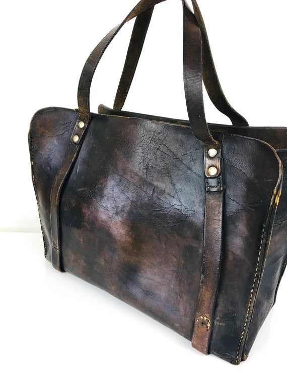 Vintage 1930s Antique Distressed Leather Bag- super old- stiffened antique leather - made of one piece of leather slab with wide sides- stands up on its own- 2 strap / handles at top attached w/ studsgreat vintage condition, some surface wear but adds to charachter13 wide5.5 deep9.5 tall 16 w/ strapsAll sales are final / as-is.We do not accept returns. Vintage Oiled Leather Bag For Everyday Use, Vintage Bag With Leather Handles In Oiled Leather, Vintage Bag With Leather Handles And Oiled Leather, Vintage Brown Oiled Leather Bag, Vintage Distressed Brown Bag For Everyday, Vintage Brown Tote Briefcase, Vintage Oiled Leather Rectangular Bag, Vintage Oiled Leather Rectangular Satchel, Vintage Oiled Leather Satchel Bag