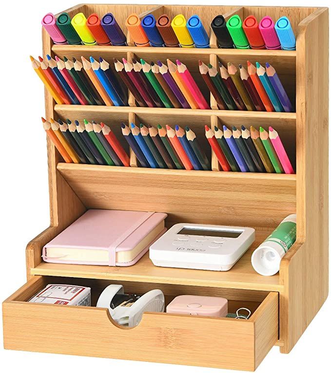 a wooden desk organizer with many different colored pencils and pens on top of it