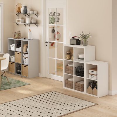 a living room filled with furniture and lots of storage space next to a dining table