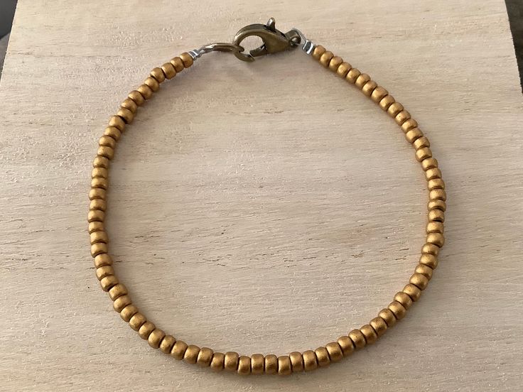 This dark gold bead bracelet features toho seed beads (size 8/0) in a striking, antique gold hue. I love the minimalist vibe to these layering pieces, and these beaded bracelets make great friendship gifts. Available in whole & half sizes, 6-9". Please ask if you have any questions. Please click below to visit my shop: https://etsy.com/shop/pepperandpomme Brass Beaded Bracelets With Round Beads, Gold Beaded Bracelets With Tiny Beads For Everyday, Everyday Tiny Beads Gold Bracelets, Everyday Gold Beaded Bracelets With Tiny Beads, Hand-strung Brass Bracelets With Round Beads, Handmade Minimalist Gold Beads, Adjustable Brass Beaded Bracelets With Gold Beads, Brass Bracelets With Round Gold Beads, Everyday Bohemian Gold Beads