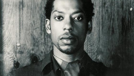 a black and white photo of a man in a suit looking at the camera with an intense look on his face