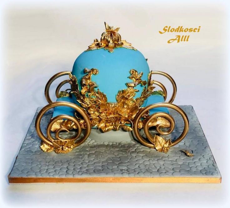 a blue and gold carriage cake on top of a silver plate