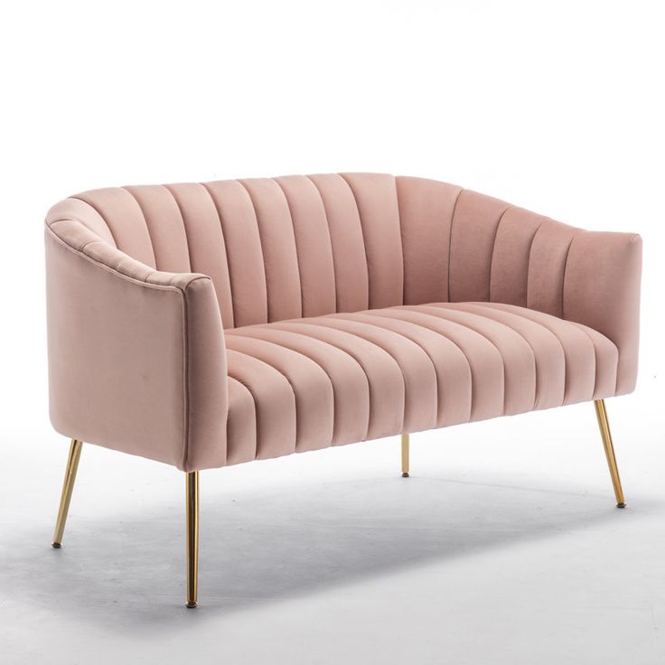 a pink velvet couch with gold legs on an isolated white background in front of a wall