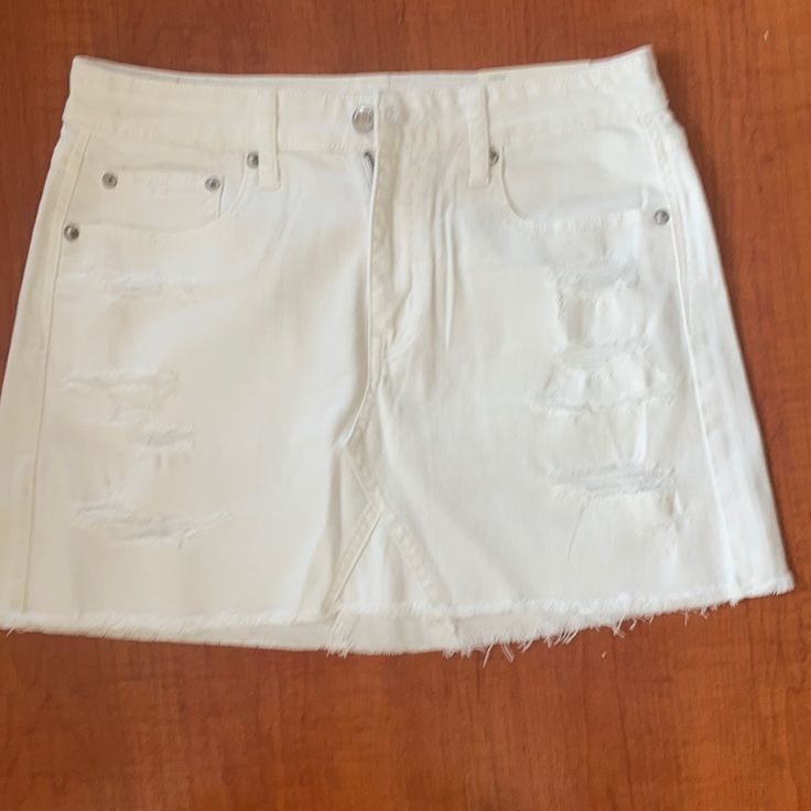 White High-Rise Vintage Denim Front And Back Pockets Distressing Throughout Trendy White Mid-rise Denim Skirt, White Denim Mini Skirt Casual, Casual White Mid-rise Denim Skirt, White Frayed Hem Mini Denim Skirt, White Denim Mini Skirt With Frayed Hem, White Denim Mini Skirt With Pockets, White Mini Denim Skirt With Pockets, Casual White Mid-rise Skirt, White High Waist Mini Skirt With Frayed Hem