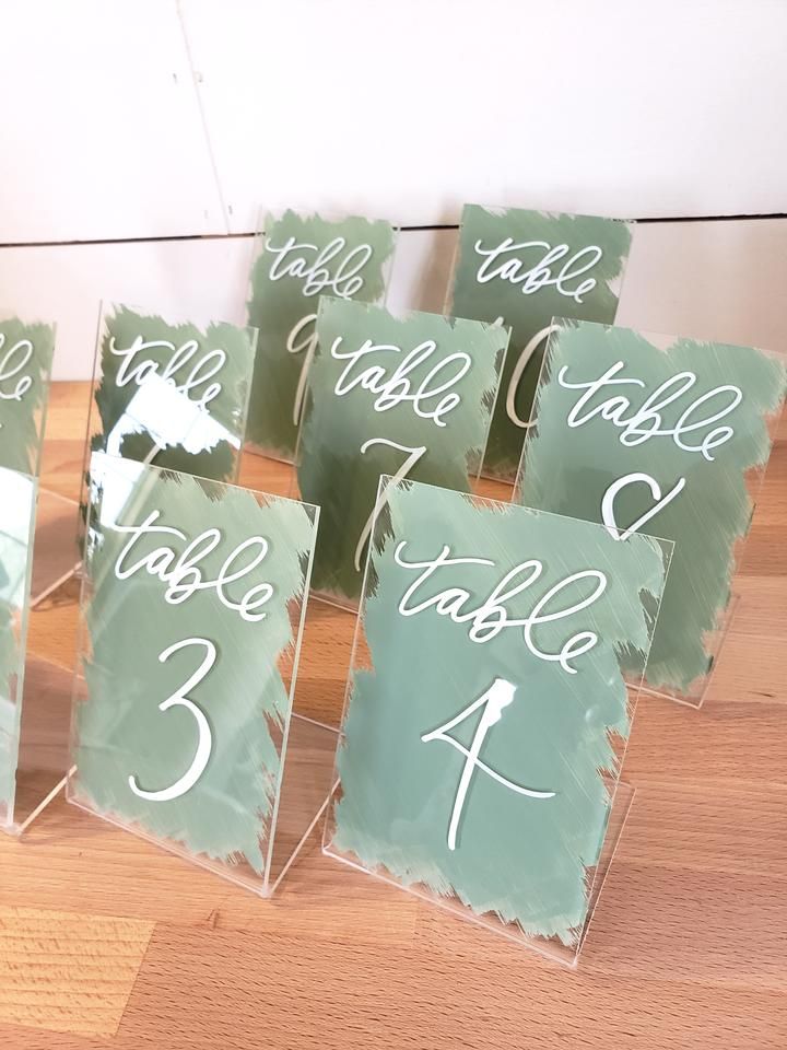 the table numbers are displayed on acrylic sheets with white ink and calligraphy