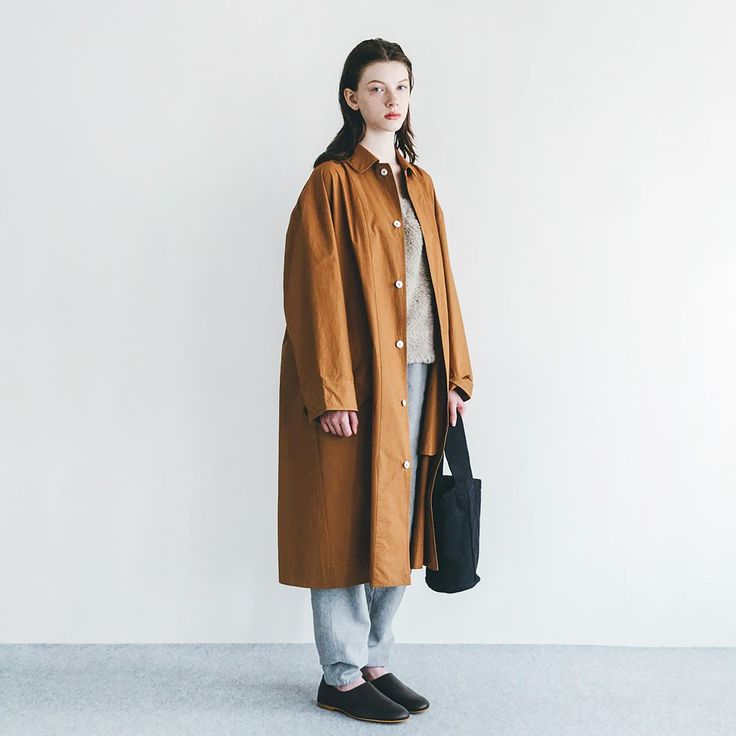 The Riddhi coat has a roomy fit with shell buttons down the front and a pointed collar. With a dropped shoulder, long sleeves that button at the cuff, and two flap button closure pockets at the front. A deep back yoke and a kick pleat at the back hem add tailored details. 100% cotton-medium weight poplin. 44" length x 52" chest x 30" neck to sleeveMachine wash gentle. Dry cool or line-dry.Fog Linen Work is a Japanese lifestyle brand founded by Yumiko Sekine during the late 1990s. With an international following, Fog is well known for its range of linen housewares + clothing, as well as its developing collection of wood, brass, and metal objects for everyday living. They endeavor to design and distribute an honest, beautiful, and long-lasting product. Oversized Outerwear With Lapel Collar And Buttons, Oversized Outerwear With Buttons And Lapel Collar, Oversized Collared Outerwear With Button Closure, Stand Collar Outerwear With Buttoned Pockets For Work, Workwear Outerwear With Buttoned Pockets And Stand Collar, Oversized Collared Outerwear With Button Cuffs, Oversized Brown Outerwear With Buttoned Pockets, Oversized Solid Outerwear With Buttons, Oversized Outerwear With Stand Collar And Button Closure