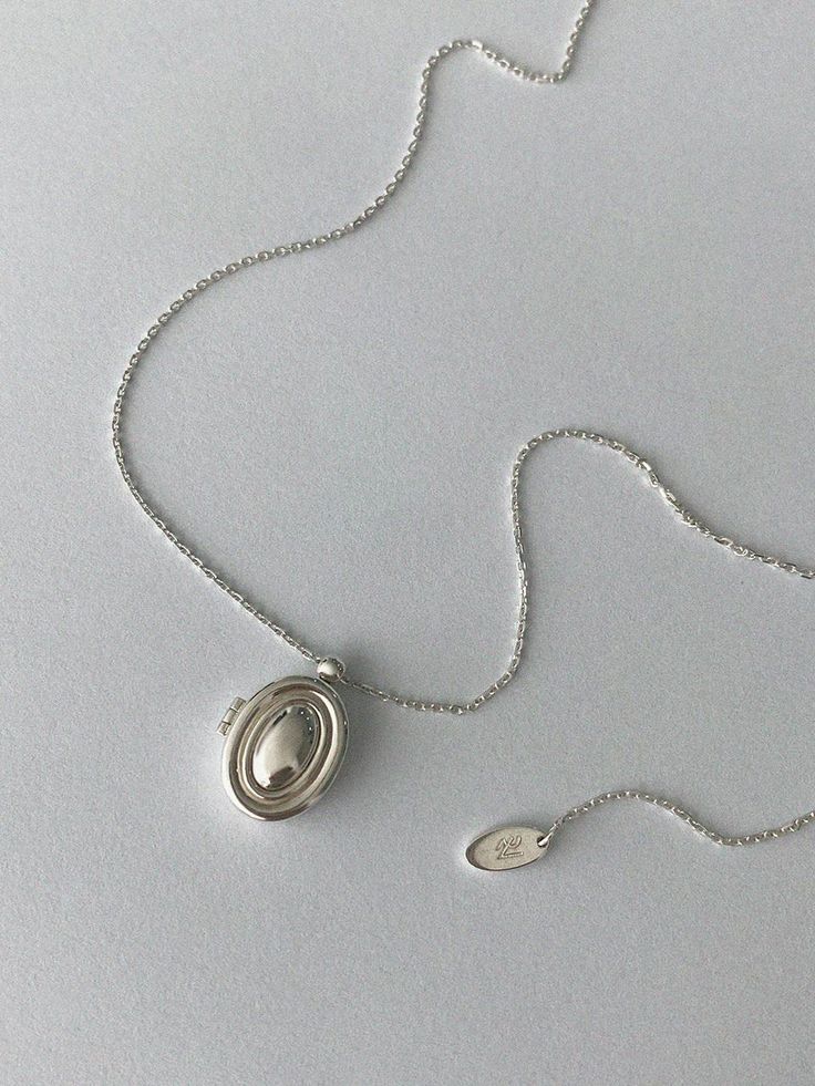 reve is demi-fine women's jewelry design brand for trendy and chic women with 20-30's. reve is a design jewelry that uses lines and chains based on kinetic aesthetics. - Mini oval locket pendant- Made of smooth and polished silver 925- Slim silhouette on the neck- Length adjustable chain with O-ring Dainty Silver Locket, Cheap Adjustable Nickel-free Locket Necklace, Luxury Silver Locket Necklace, Small Silver Locket, Elegant Pendant Locket Necklace For Everyday, Elegant Everyday Pendant Locket Necklace, Elegant Silver Locket Necklace For Everyday, Formal Round Pendant Locket Necklace, Elegant Silver Locket Necklace