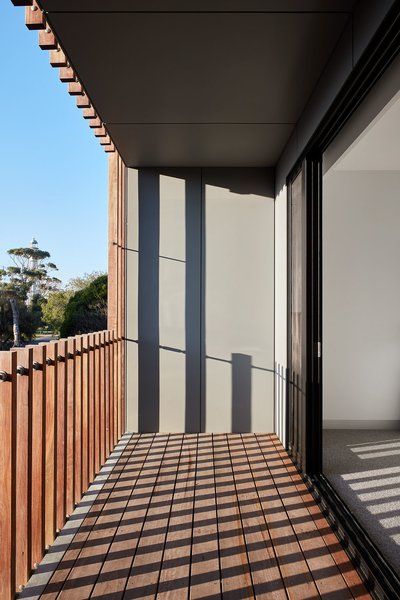 an empty balcony with wooden slats and sliding glass doors