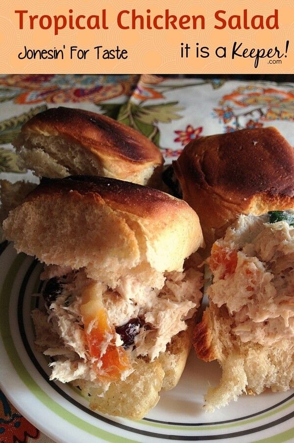 two chicken salad sandwiches on a plate with the words tropical chicken salad written above them