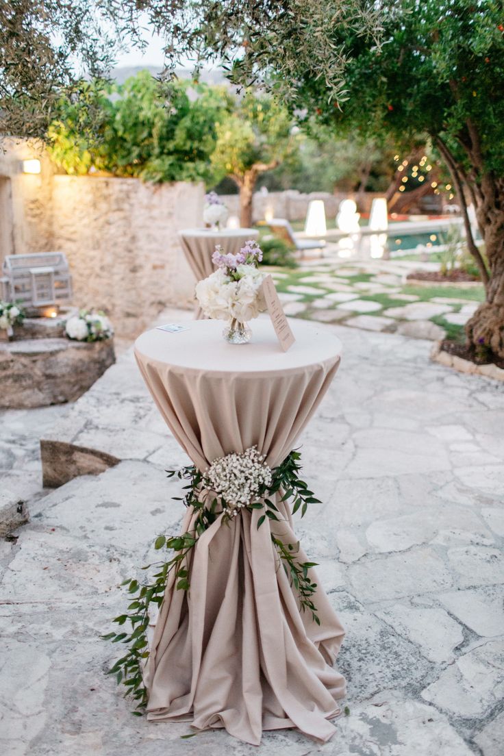 an outdoor table with flowers and greenery on it is set up for a wedding reception