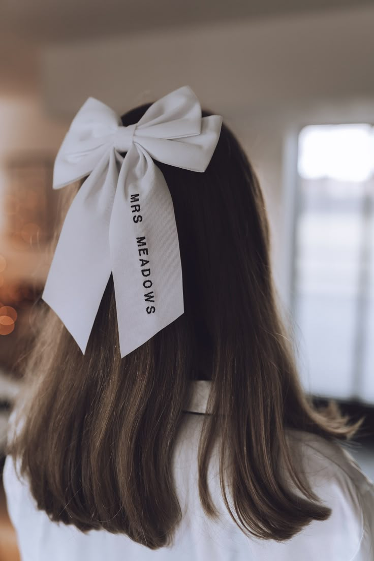 a woman with long hair wearing a white bow