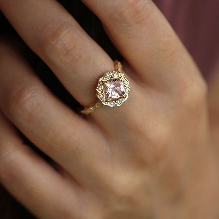 with an antique touch and a royal presence this ring is for a real princess. The center stone is a breathtaking morganite with a pinkish glow to it held by 8 magnificent claws. The stone is surrounded by 12 dazzling white diamonds set exquisitely in paisley like gold shapes. The band is waivy gold, dotted and encrusted with diamonds as well. This ring is just heart stopping from every angle. All features can be customized! please contact us if you wish to make changes, we love making custom designs. All of our jewelry is carefully handmade in our atelier *HC diamond are all conflict free diamonds To order by phone click here>> +972(0)722991000 Heirloom Morganite Diamond Ring For Formal Occasions, Elegant Morganite Diamond Ring With Gemstone, Exquisite Formal Morganite Ring, Luxury Morganite Ring With Prong Setting, Heirloom Pink Jewelry With Center Stone, Asscher Cut Diamond Wedding Ring With Accent Stones, Formal Pink Gold Morganite Rings, Wedding Asscher Cut Diamond Ring With Accent Stones, Exquisite Rose Gold Morganite Ring