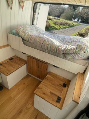 the interior of a small camper with stairs and storage boxes on the floor,