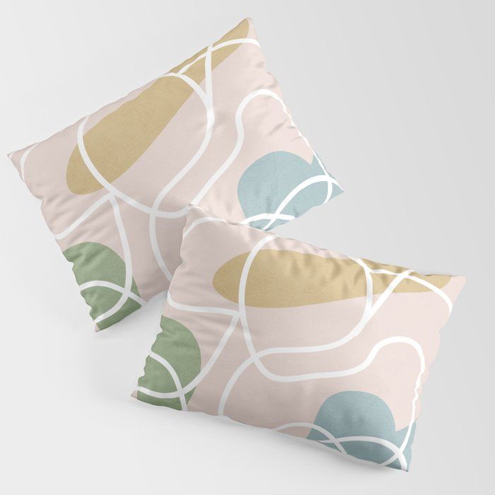 two decorative pillows sitting next to each other on a white surface with green and blue circles