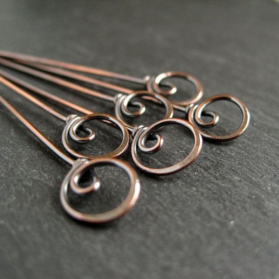 five pairs of silver colored metal hair pins on a black surface, with one set of six in the middle