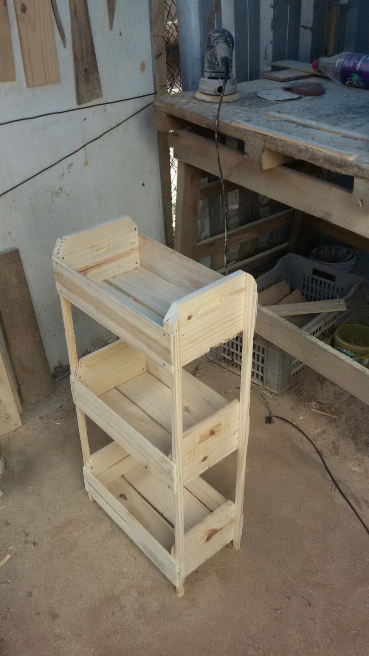 a wooden shelf sitting in the middle of a room next to a workbench