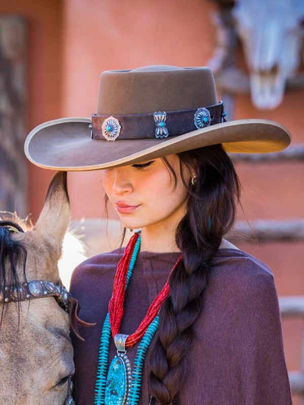 This is the flagship Brit West concho hatband for sure! Beautifully inspired from our custom concho belts with 1.5 inch custom conchos. Matching our famous Navajo concho hair tie, such a great piece to pair. I have searched the world over for perfect vintage leather and great colorful American turquoise. These hatbands are made from old latigos, used by cowboys across the American west. Stones will vary, but are mostly soft greens and blue American turquoise. These are sized to fit any hat with adjustable slides and leather tassel. Custom build time could be 4 weeks, but we do our best to keep these in-stock! Country Style Concho Hat Band For Rodeo, Western Concho Hat Bands For Country Events, Western Concho Hat Bands For Rodeo, Southwestern Style Concho Hat For Rodeo, Western Concho Jewelry, Western Concho Hat Band For Festival, Southwestern Style Hat Bands For Rodeo With Flat Crown, Western Style Concho Jewelry For Shows, Adjustable Western Concho Hat Bands