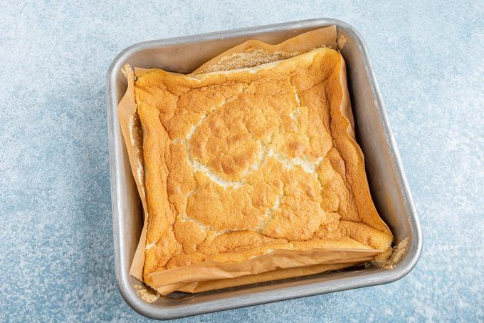 a loaf of bread sitting in a pan on top of a blue tablecloth covered floor