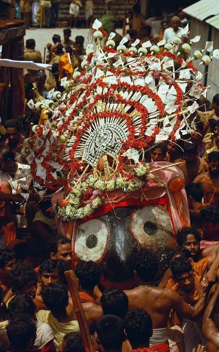 a group of people standing around a man with a mask on it's head