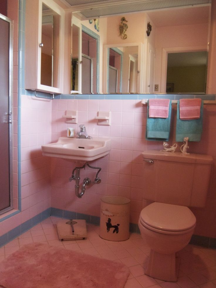 a bathroom with pink walls and flooring is pictured in this image, there are towels hanging on the wall next to the toilet