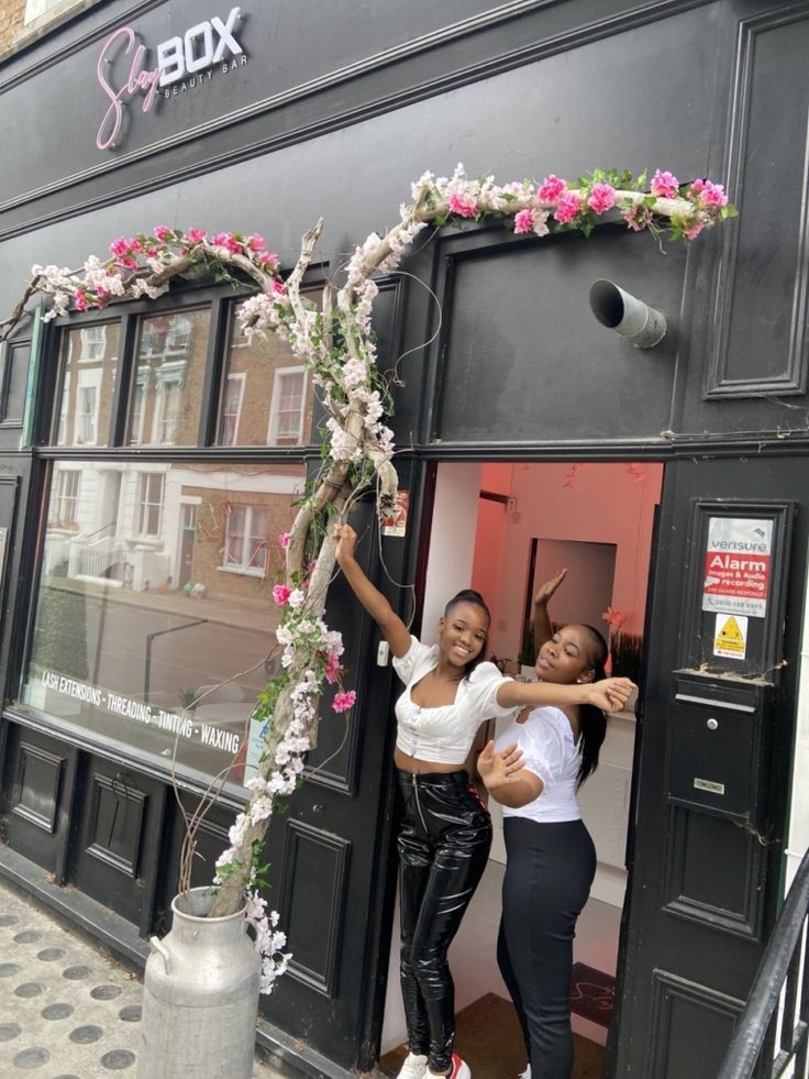 two women standing in the doorway of a store