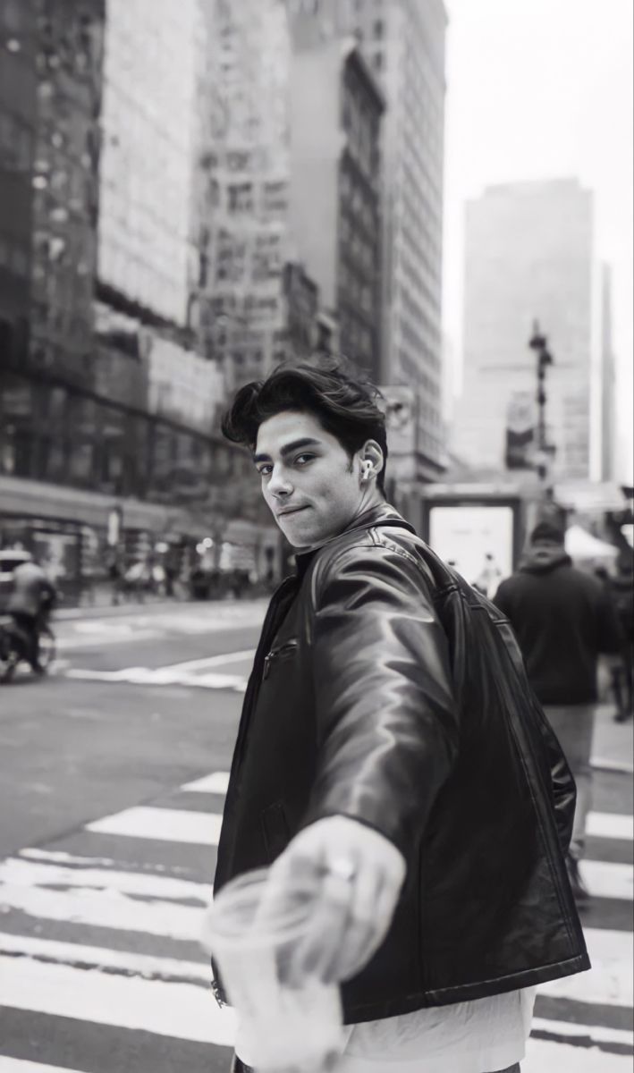 a man in a leather jacket crossing the street