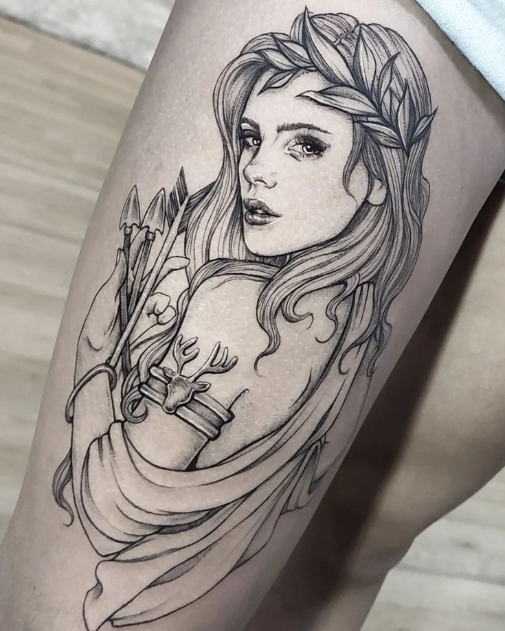 a woman's leg with a tattoo on it and flowers in her hair,