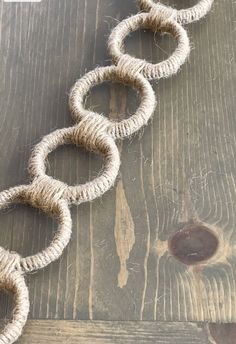 a piece of rope that is laying on top of a wooden floor with two rings attached to it