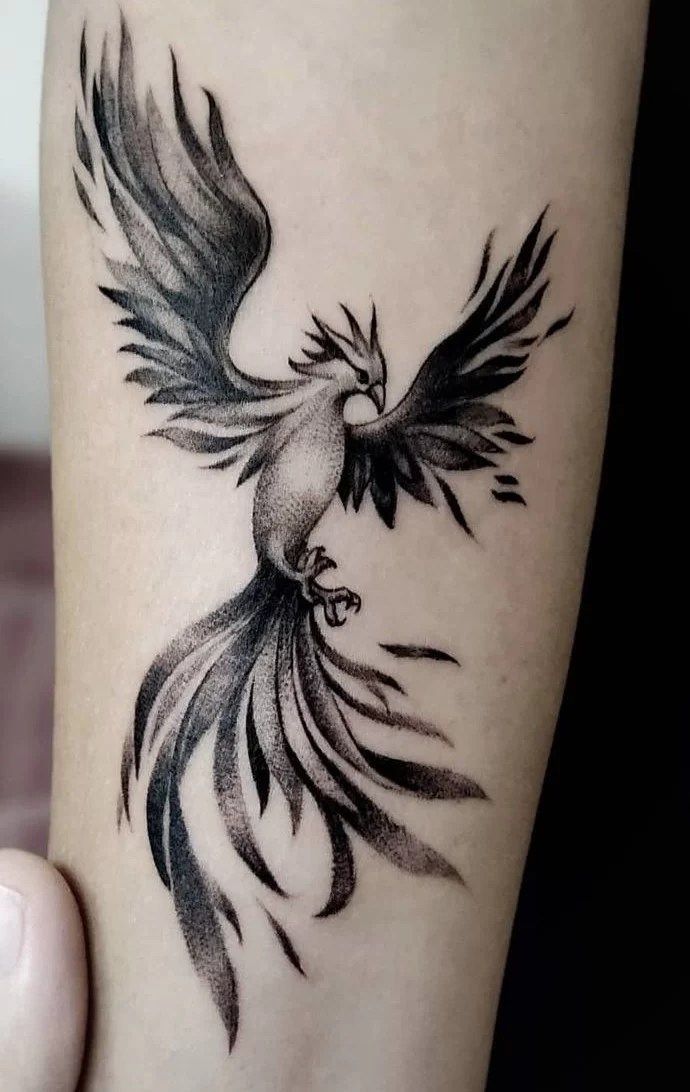 a black and white bird tattoo on the arm