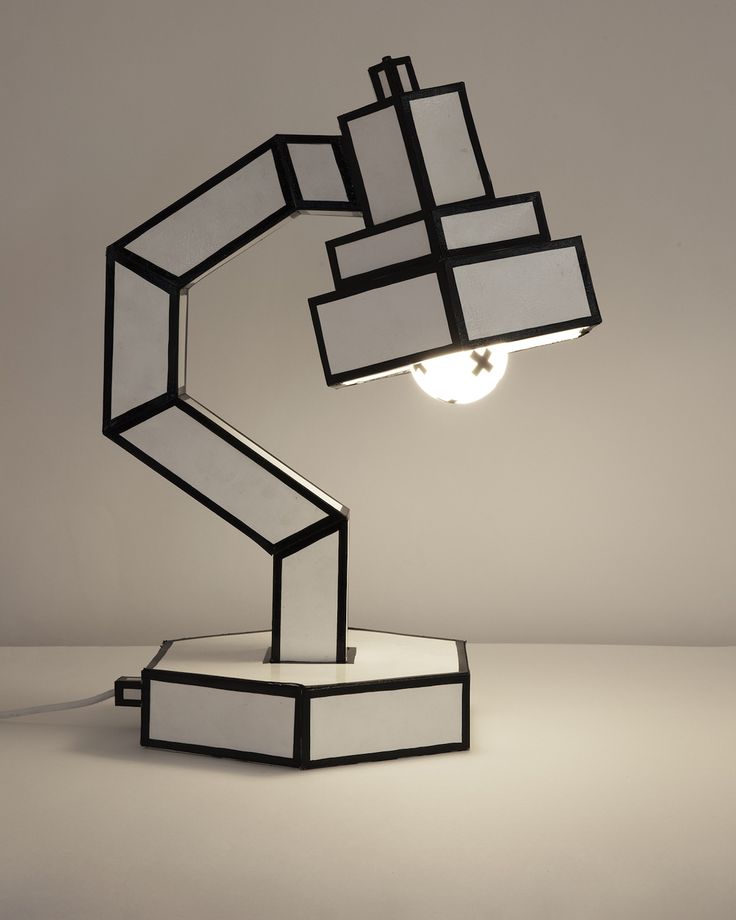 a lamp that is sitting on top of a white surface with black and white squares