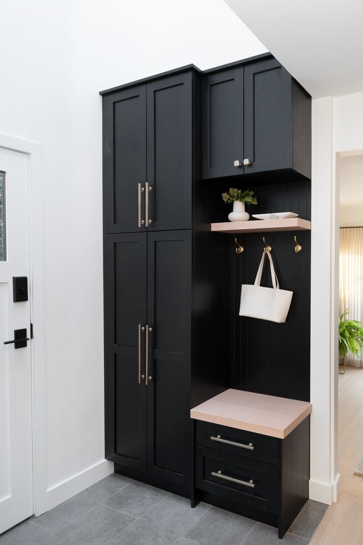 an entryway with black cabinets and drawers