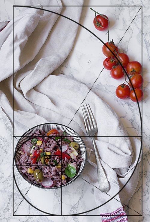 a bowl of food sitting on top of a table next to a knife and fork